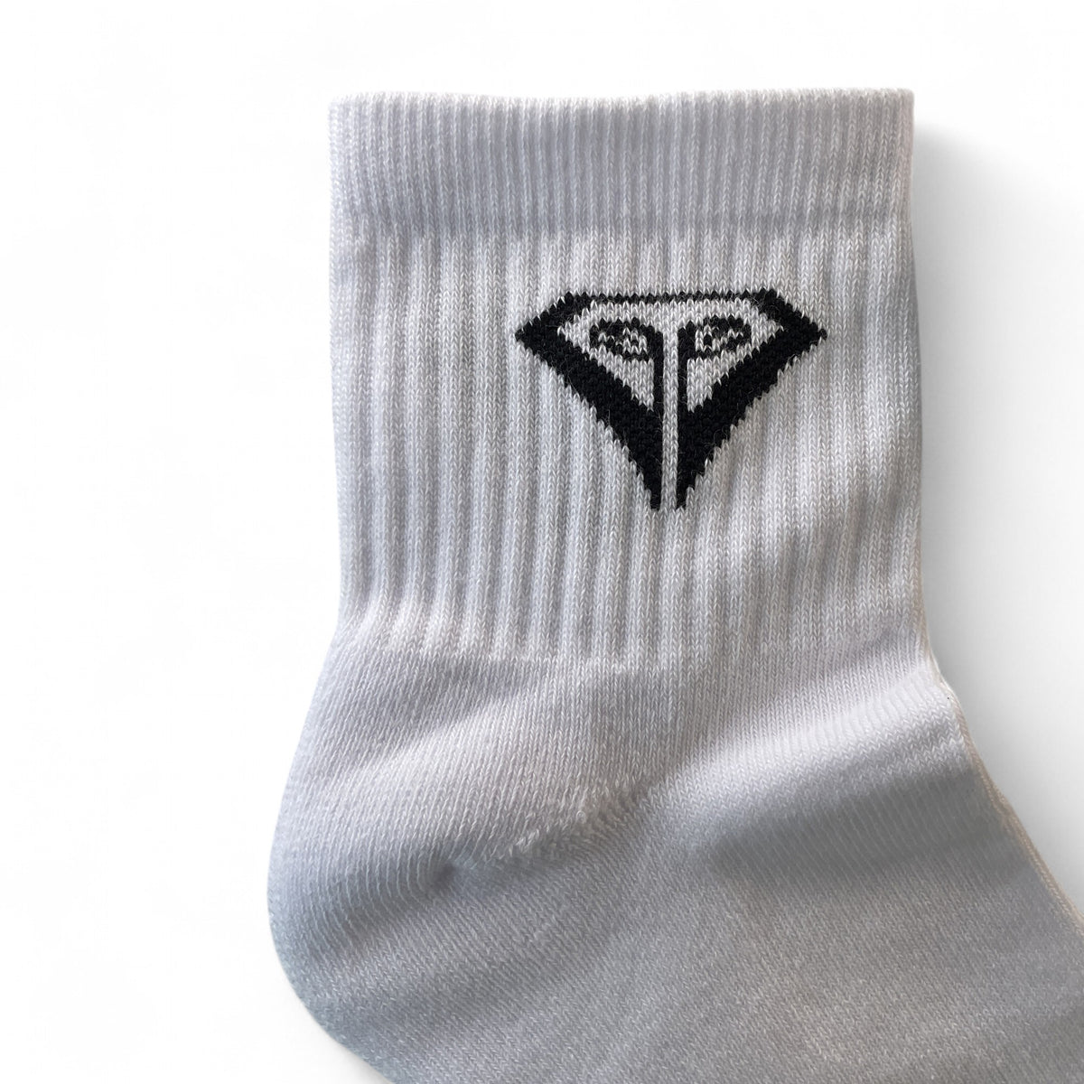 La Vita Golf Classic Crew Sock in White, close-up of the ribbed cuff and knitted black diamond crest.